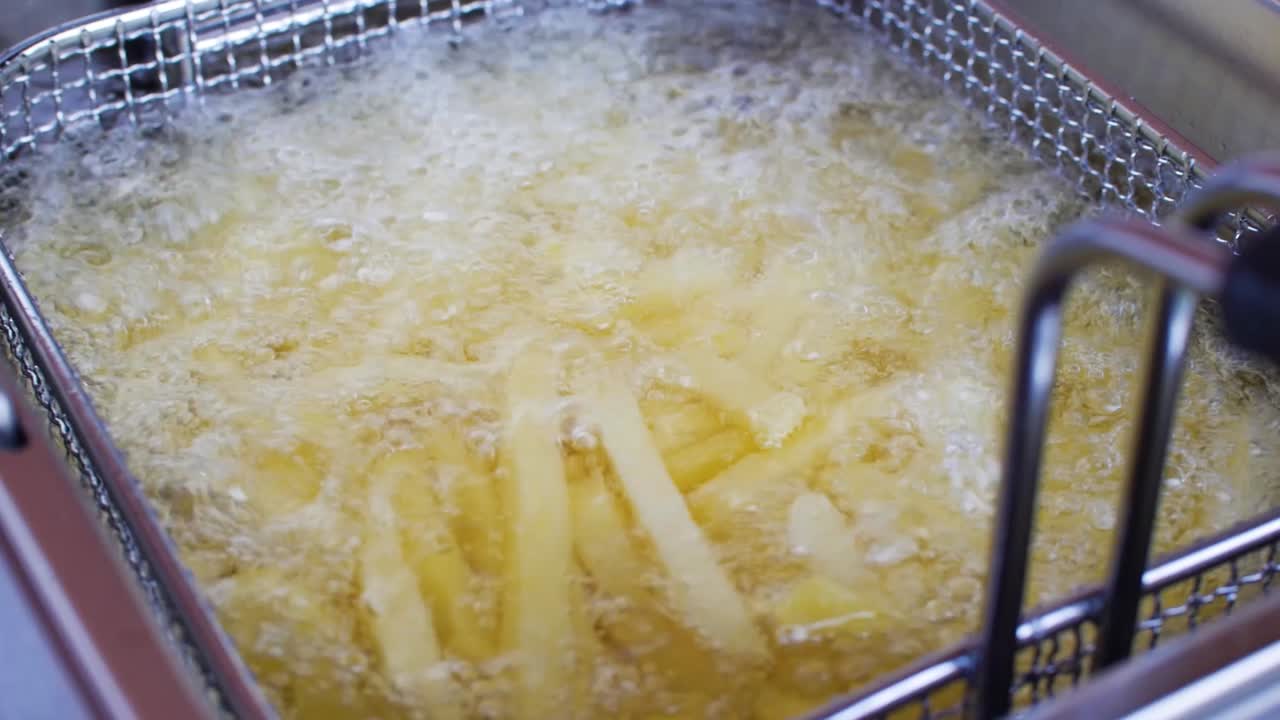 냉동 된 감자 가 뜨거운 기름 에 김 을 하고 있는 것