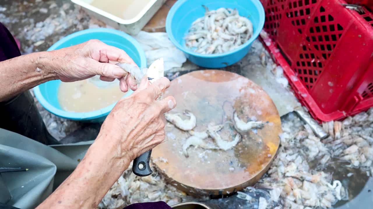 손으로 목판 위에 새우를 청소하고 준비하는 것