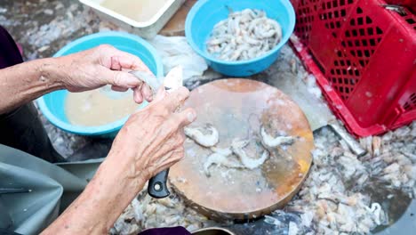 limpieza de manos y preparación de camarones en una tabla de madera