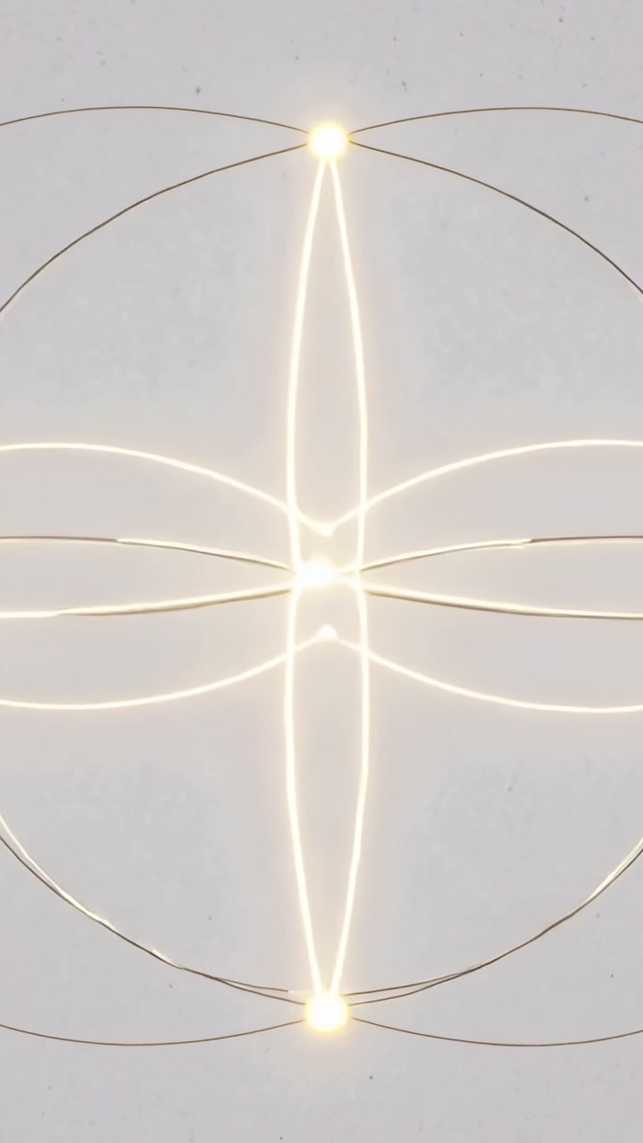 Vertical video: Starting symmetrical light ornament forming on gray canvas, glowing arcs and nodes