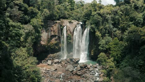 aerial view of nauyaca waterfalls with with pristine water running down into rocky river in costa rica