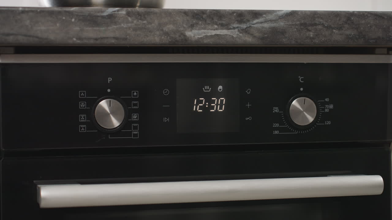 Digital display on tabletop gas oven with grill shows settings including timer at 12:29, temperature control, and function modes, highlighting modern kitchen appliance interface and precise cooking setup