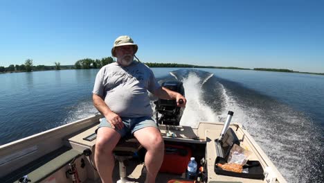 old man driving fishing boat fast sunny day