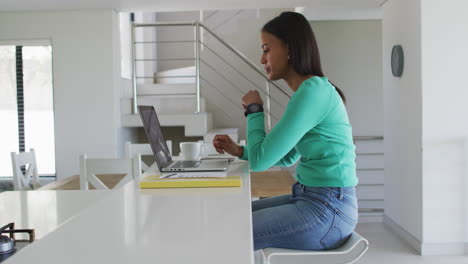 african american woman using laptop while working from home