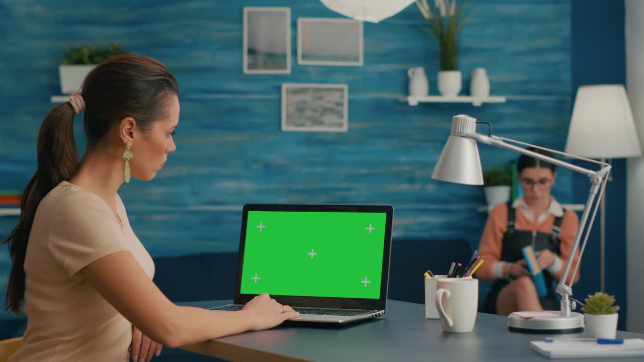 freelancer usando una computadora con una pantalla verde simulada y una tecla de croma