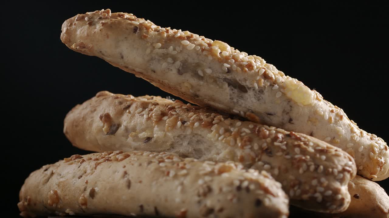 imágenes de un baguete de pan giratorio sobre un fondo negro