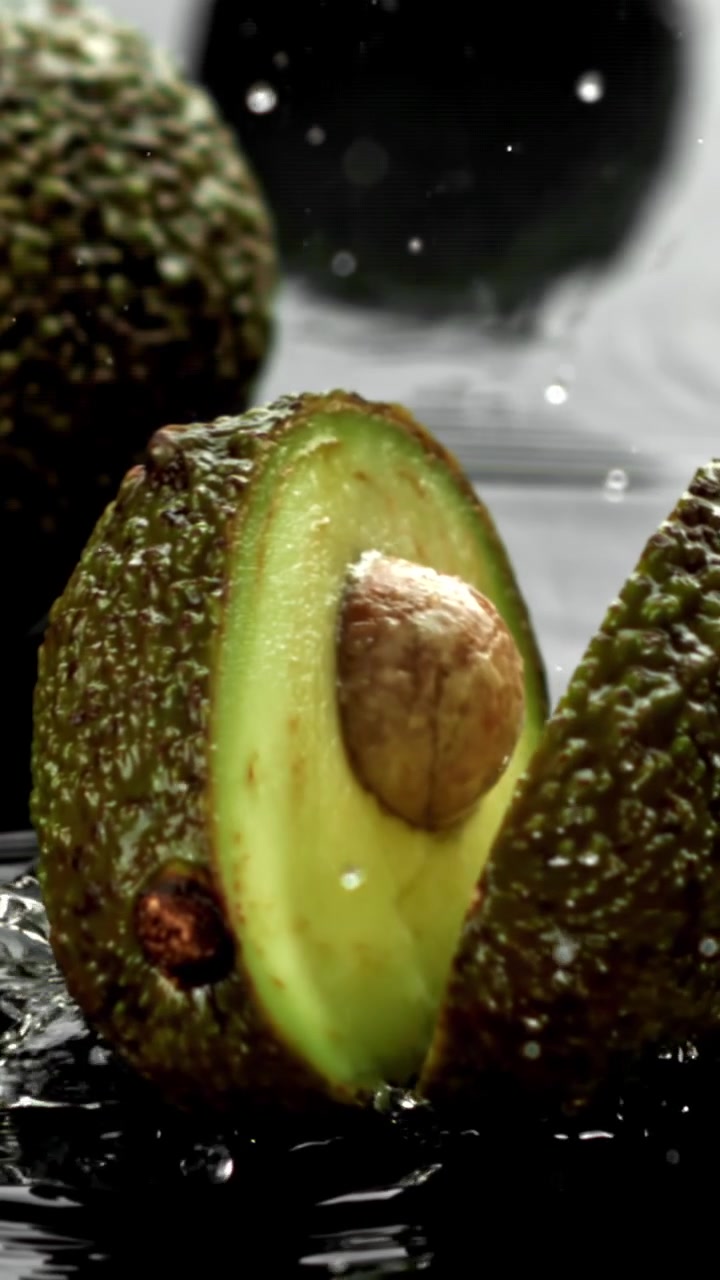 Avocado che si divide a metà con schizzi d'acqua al rallentatore
