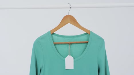 Video-Von-Grünem-T-Shirt-Mit-Etikett-Auf-Kleiderbügel-Und-Kopierraum-Auf-Weißem-Hintergrund
