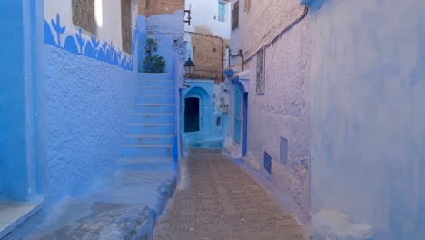 pov shot walking along alleyway in chefchaouen, beautiful vibrant blue painted walls, morocco