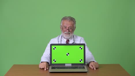 hombre barbudo y guapo en el fondo verde.