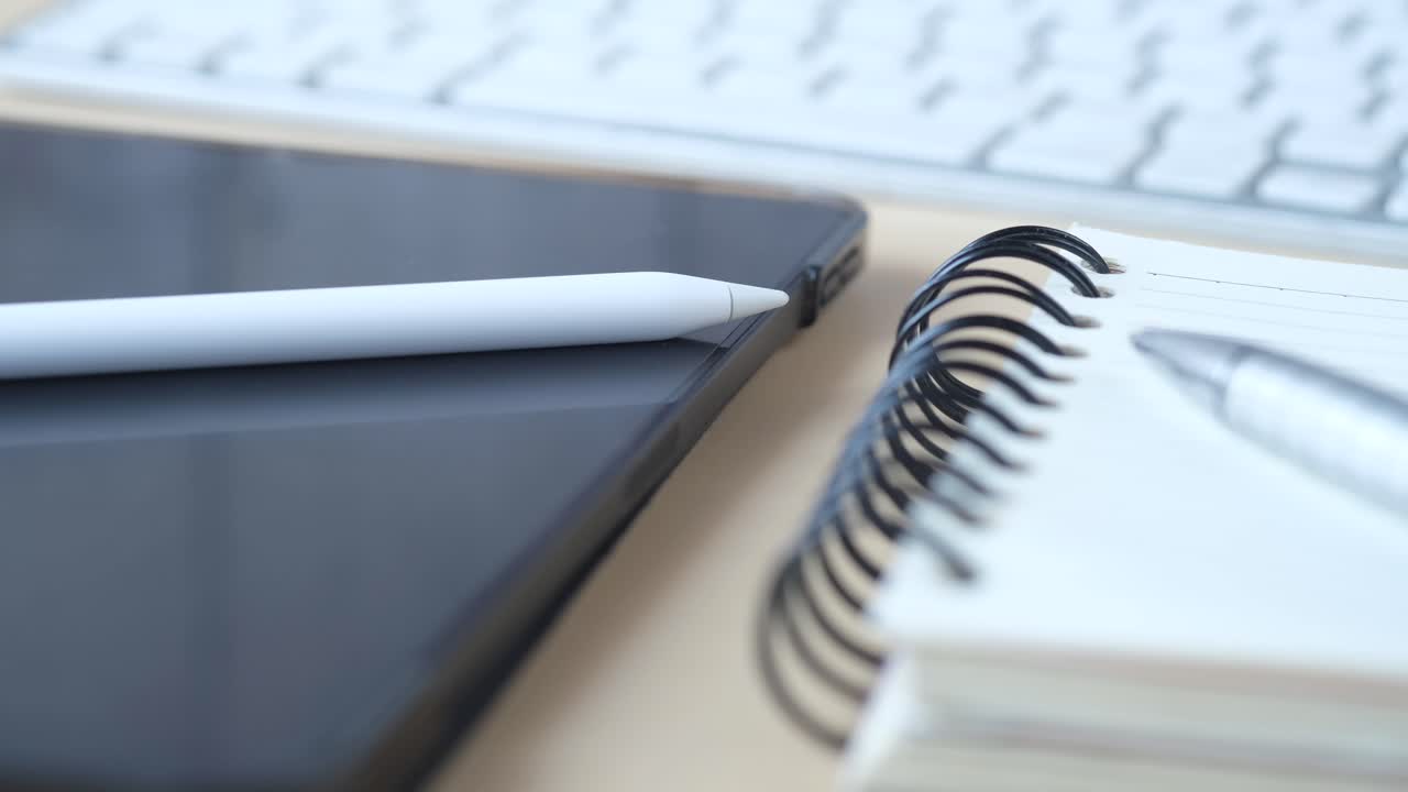 Modern workspace with tablet, stylus, notebook, and keyboard