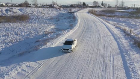 white car driving on snowy country road