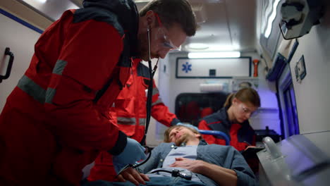 ems paramedics measuring man blood pressure