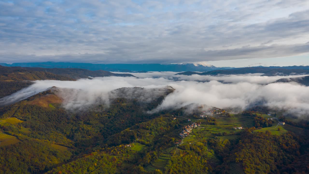niebla densa de otoño matutino rodando sobre la cresta de la ladera hacia el valle, lapso de tiempo aéreo