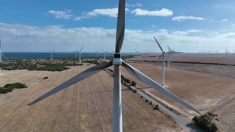 ascending drone shot of spinning wind turbine