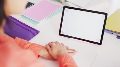 Video-of-smiling-biracial-woman-with-dark-hair-using-tablet-with-blank-screen