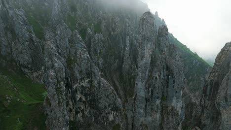a breathtaking view of the jagged, rugged peaks of mount grignetta, shrouded in mist, in lombardy, italy - pan up shot