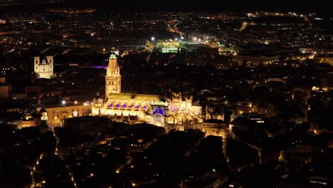 70mm drone filming of the city of toledo at night, we see its cathedral as a central element very illuminated, since it is an emblematic icon, magic is created through its night streets. dazzling