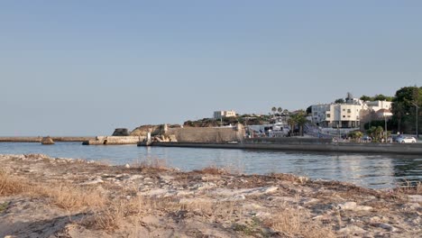 coastal view of lagos in portugal with sandy foreground and distant buildings