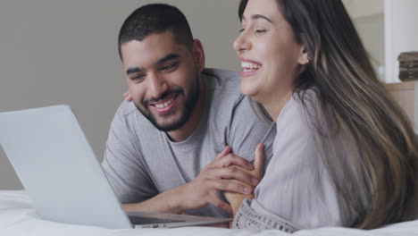 una joven pareja feliz usando una computadora portátil
