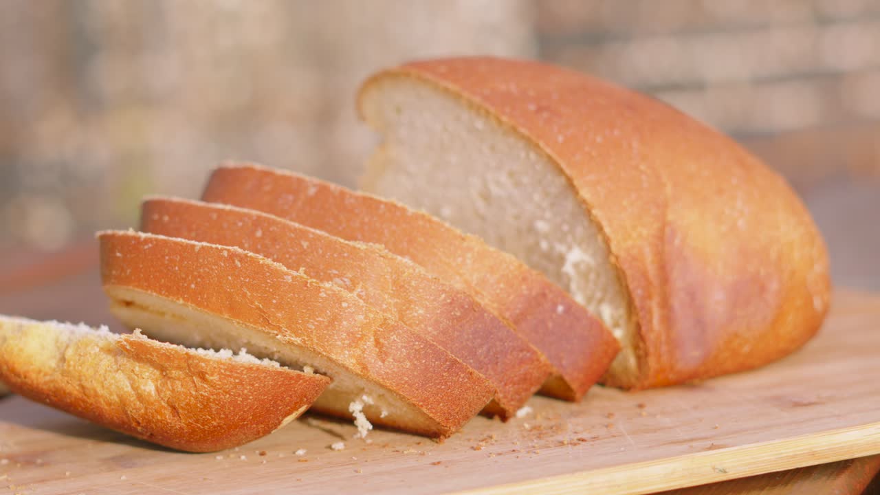 Outdoors Medium Shot of Freshly Baked Homemade White Bread with Slices on Wooden Chopping Board. Home Baking Footage with Simple Healthy Ingredients Outside 4K.