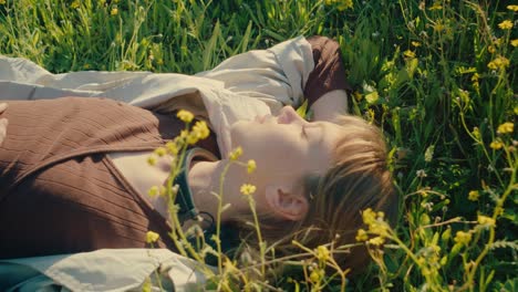 Girl-lying-in-lush-meadow-with-wildflowers-in-afternoon-sun-daydreaming