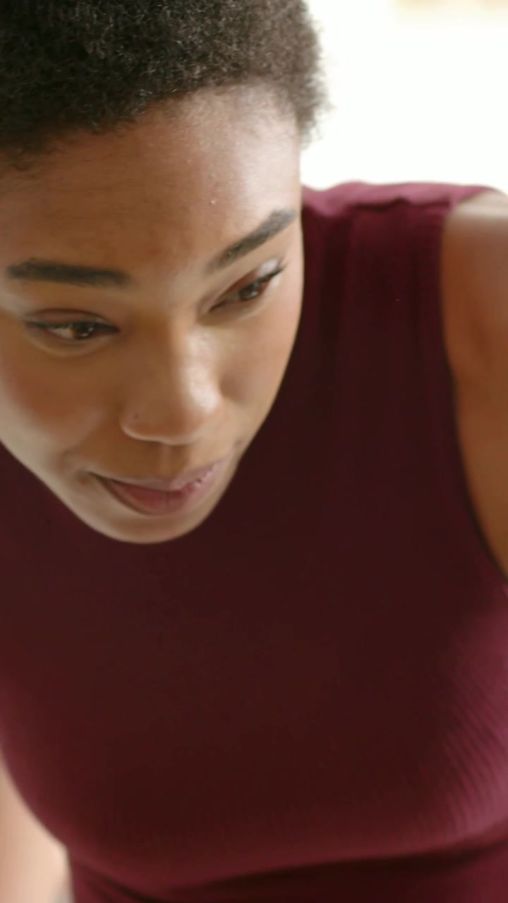 Vertical video: Leaning after seated look woman maroon top pointing phone at laptop at desk showing