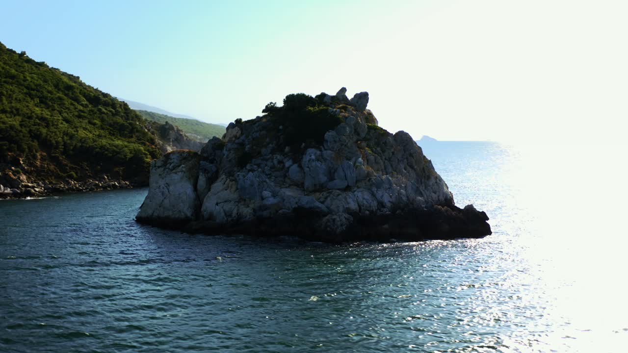 vista aerea della piccola isola rocciosa e terra sullo sfondo in una giornata di sole