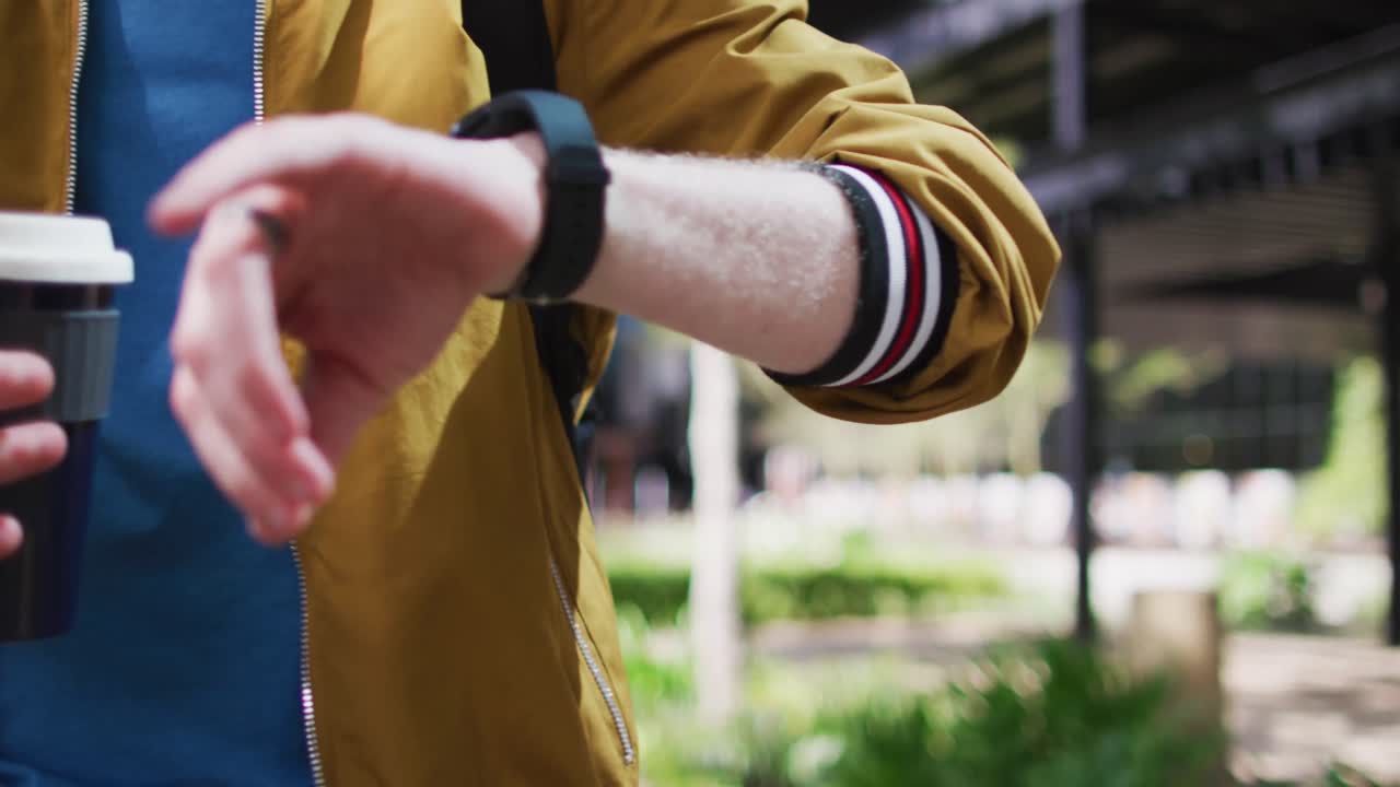 hombre albino afroamericano usando un reloj inteligente y bebiendo café