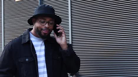 hombre negro riendo hablando teléfono inteligente