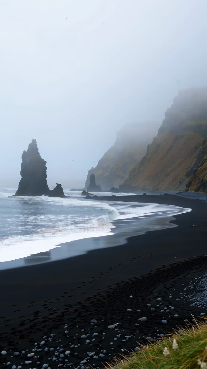 Dramatic Black Sand Beach with Sea Stacks in Fog