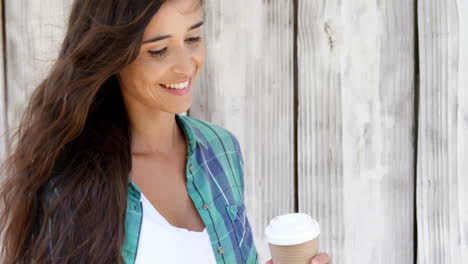 Mujer-Joven-Usando-Un-Teléfono-Móvil-Y-Tomando-Café-En-Un-Vaso-Desechable