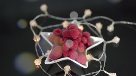 beautiful red raspberries in star dish surrounded by star lights and floating orbs