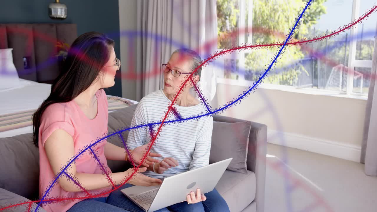 Mid-adult daughter typing on laptop teaching mother tech, helix graphic drifting over laptop screen