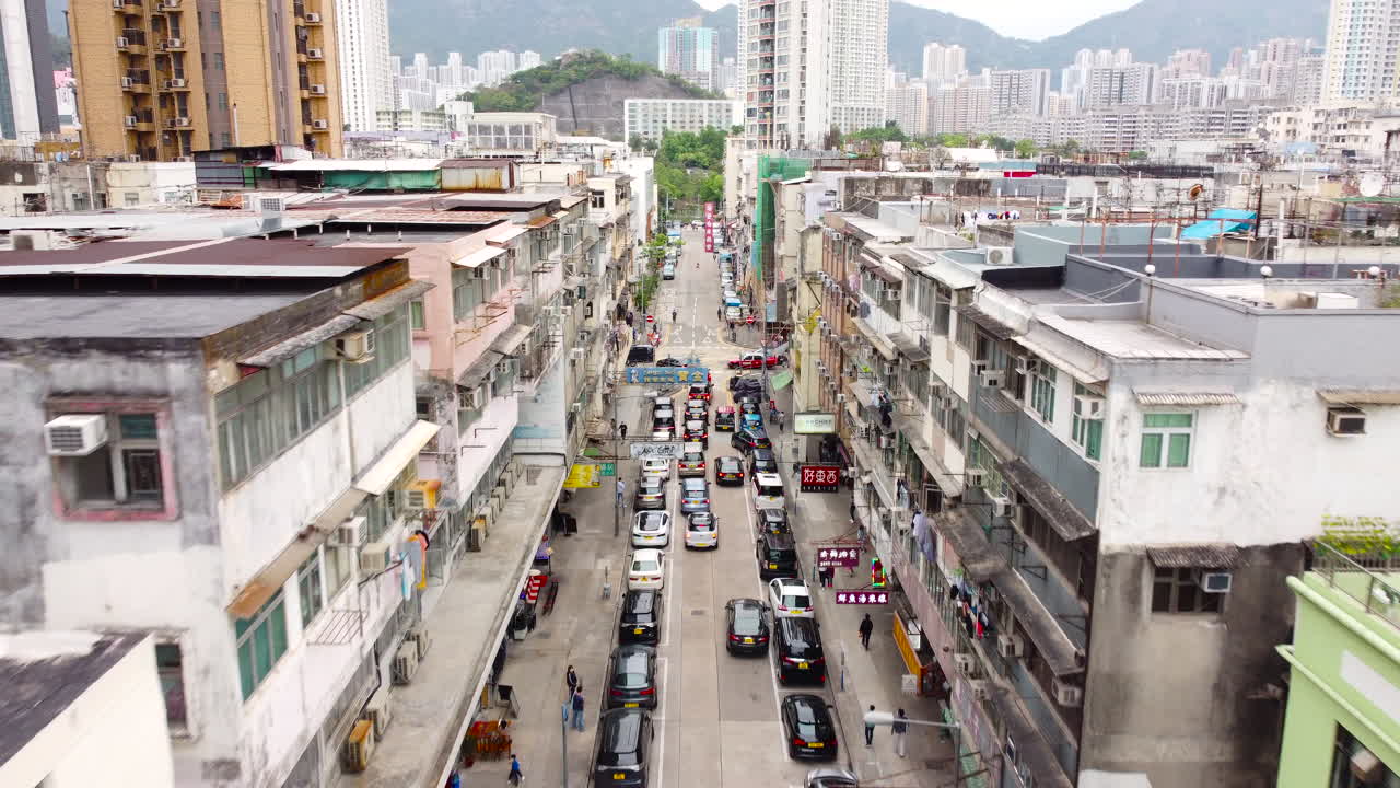 Ariel Drone Dolly push in over Kowloon City, Hong Kong, Birdeye view showing traffic jam surrounded by traditional airfield levitate through city. Kai Tak Airport.