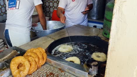 close up of two man frying tunesian speciality dough rings bambalouni in sidi bou said close to tunis tunesia