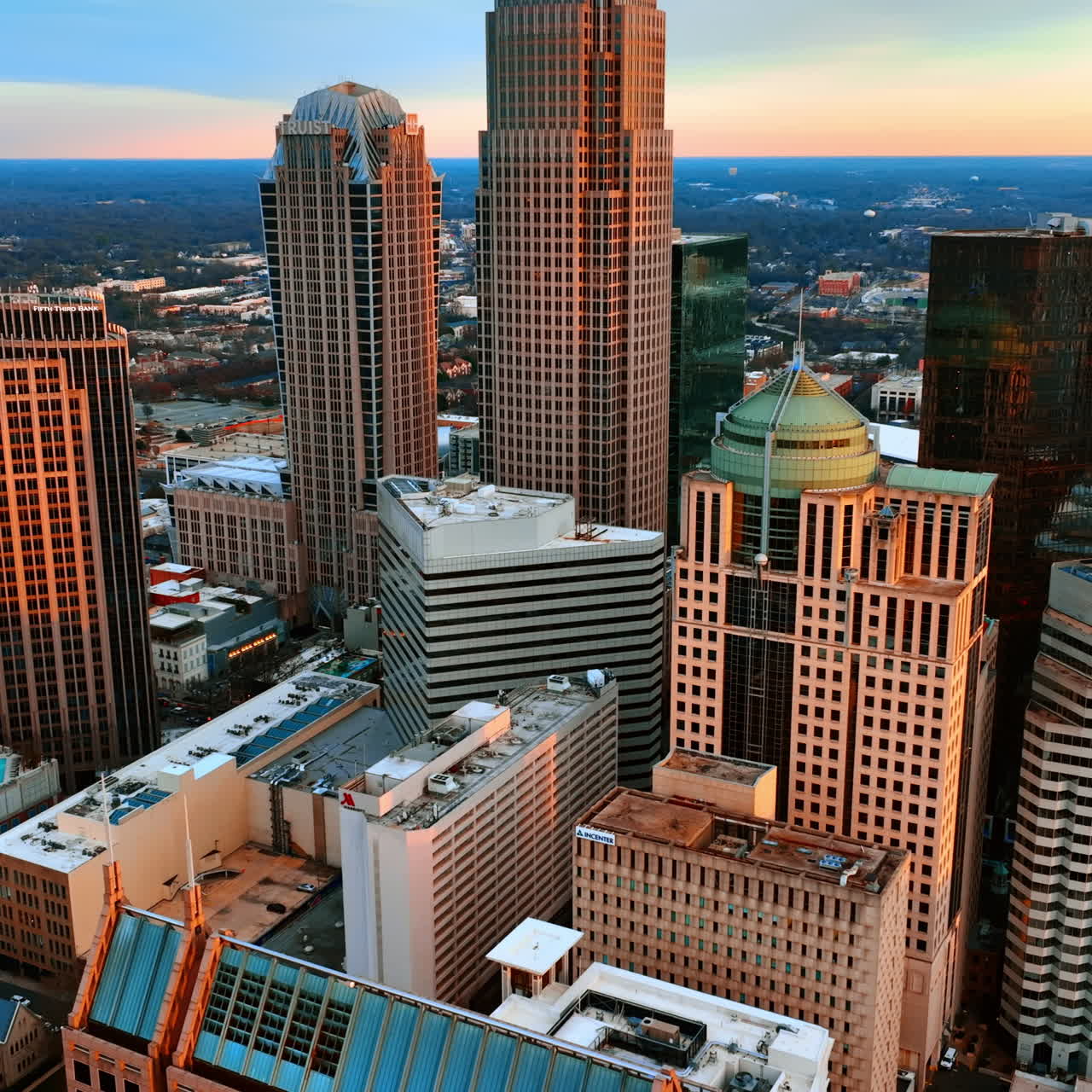 Soft orange light covering the skyscrapers in the uptown of Charlotte, North Carolina, the USA. View on the American city at sunset from top.