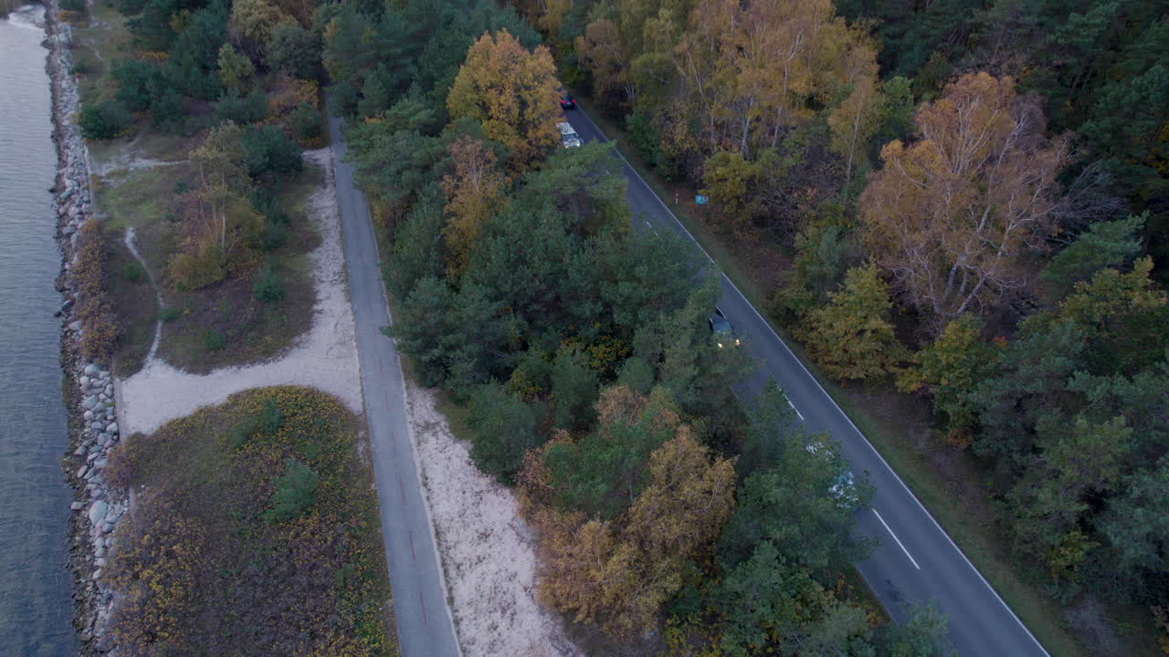 가을에 발트해 근처의 해안 도로에서 운전하는 자동차의 공중  다운  - 아래로 기울이는 움직임
