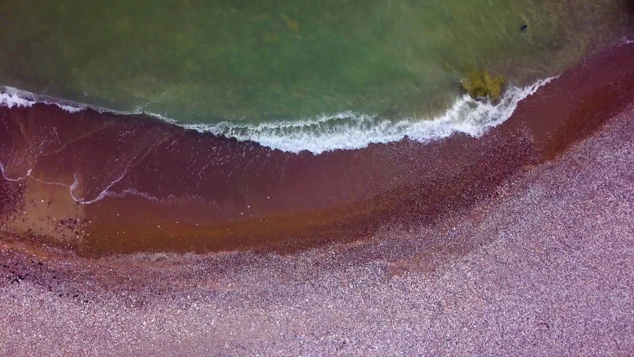 vista aérea de pájaro de edificios abandonados de fortificación junto al mar en los fuertes del norte de karosta en la playa del mar báltico en liepaja, letonia, tranquilas olas del mar rompiendo contra la orilla, amplio disparo estático de drones