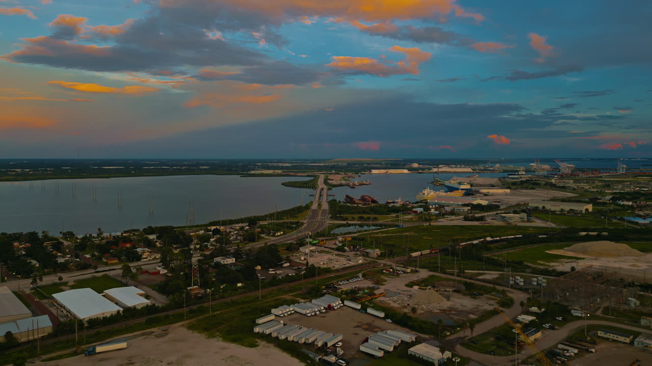Early morning aerial of Tampa city blocks, roads, and waterfront, soft glow on clouds