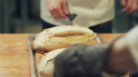 close-up, the baker turns the bread and puts it in the oven