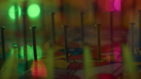 plinko ball drops and bounces off of nail pins in board at carnival