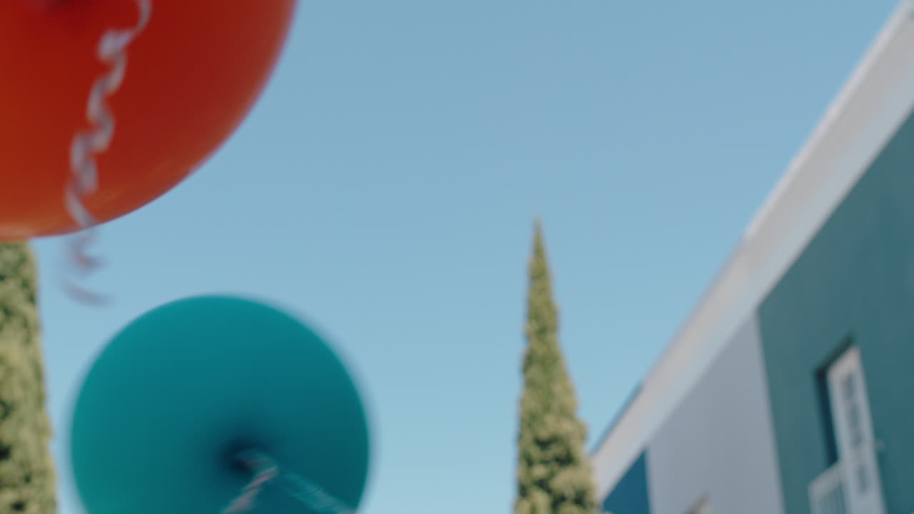 도시 거리에서 달리는 다채로운 풍선을 들고 있는 소녀 생일 파티가 여름 재미 4k를 축하합니다.