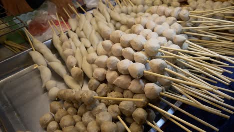 Mercado-Nocturno-De-Tailandia-Puesto-De-Comida-Callejera-Carne-De-Cerdo-Pescado-Albóndigas-En-Palitos-Listas-Para-Cocinar