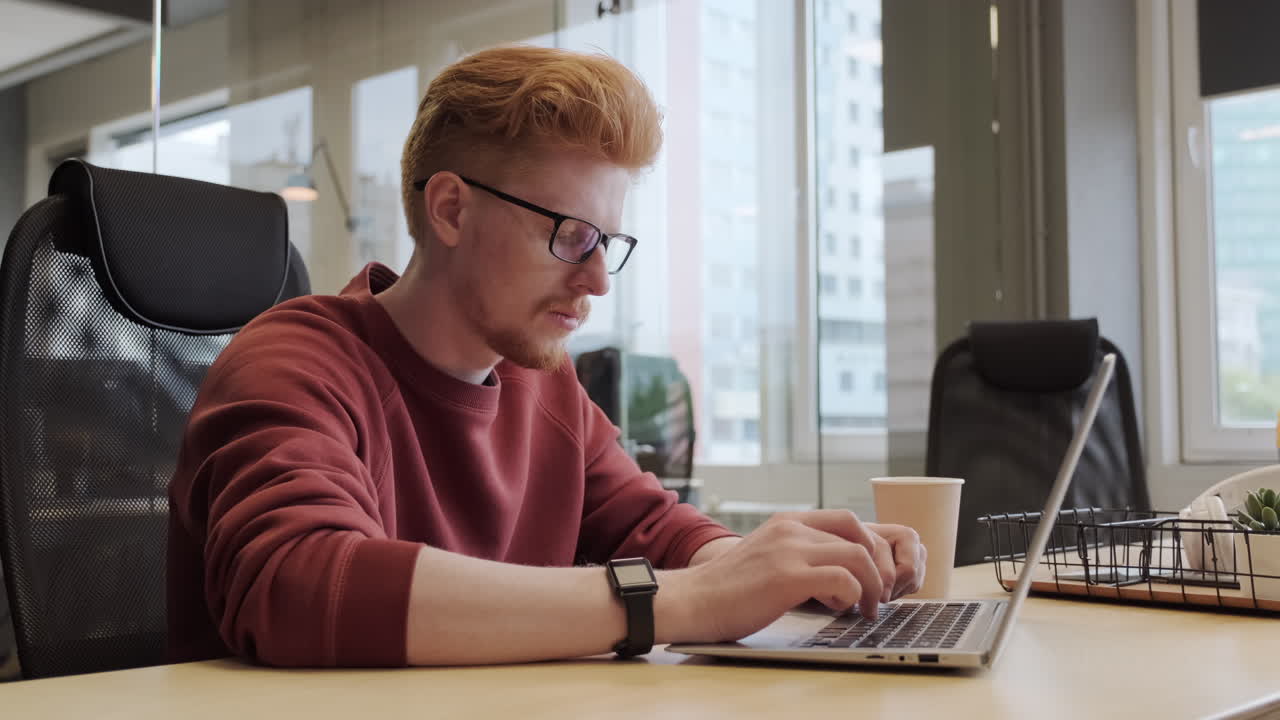 Male Office Worker Typing On Laptop