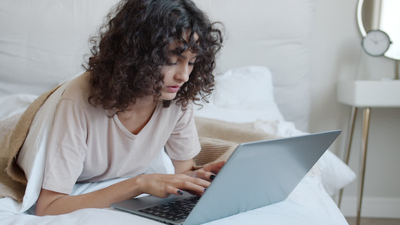 mujer trabajando en la computadora portátil en la cama