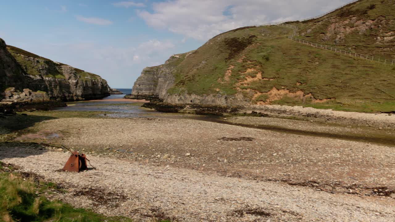 Panning shot of the beautiful stone beachat low tide at Smoo Cave