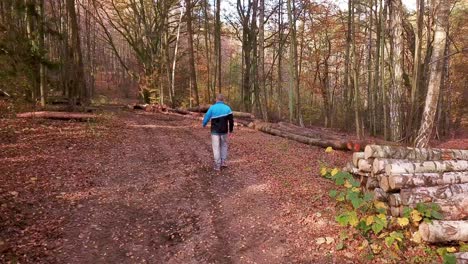 Young-Man-Walking-Through-a-Forest-in-Autumn-Scenery