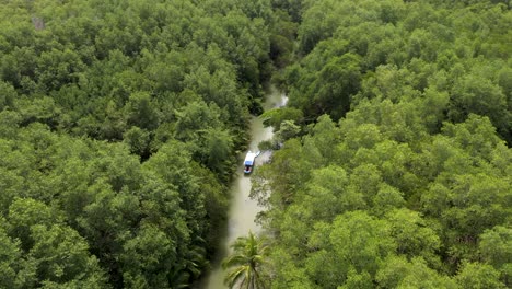 drone shot tracking a boat on a river in the jungles of costa rica