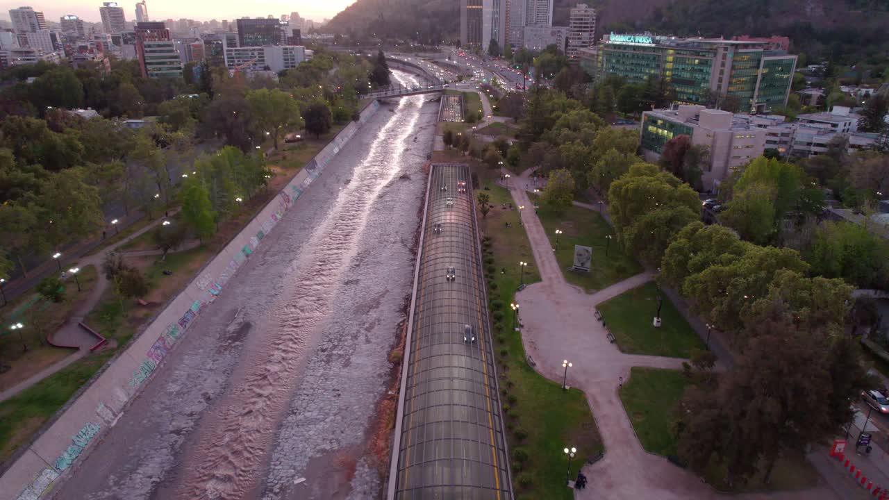 vehículos circulando por la autopista costanera norte a lo largo del río mapocho y el parque en providencia, región metropolitana de santiago, chile